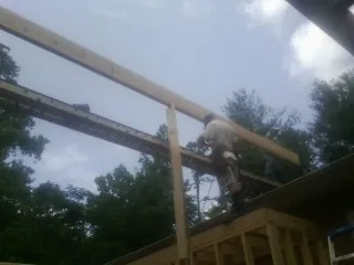 Carpenter setting a ridge beam over a new addition frame — Ice Dam Removal by Roofing Brothers in Brinklow