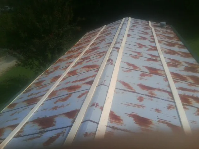 Rusted metal roof panels with new wood purlins before replacement — Storm Damage Roof Repair in Brinklow by Roofing Brothers